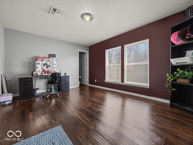 home office featuring visible vents, baseboards, a textured ceiling, and wood finished floors