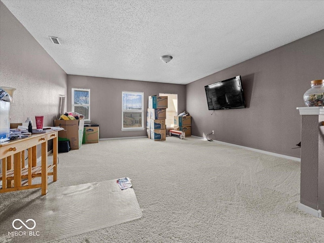 interior space with visible vents, a textured ceiling, carpet, and baseboards