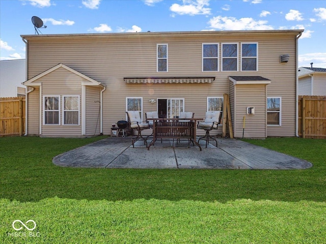 rear view of house with a patio, fence, and a lawn