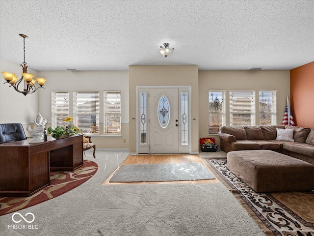 foyer featuring an inviting chandelier, plenty of natural light, and a textured ceiling