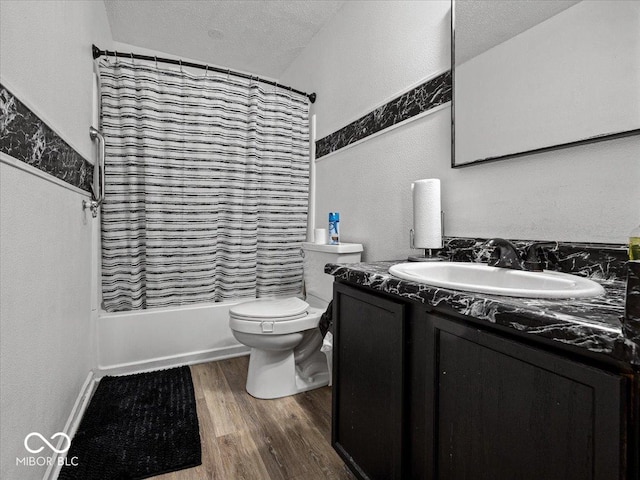 bathroom featuring shower / bath combo with shower curtain, toilet, a textured ceiling, wood finished floors, and vanity