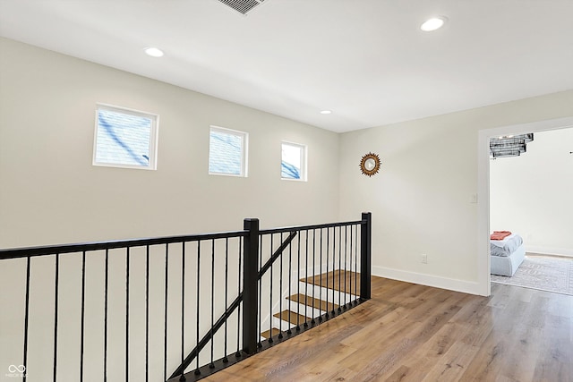 hallway featuring recessed lighting, baseboards, an upstairs landing, and wood finished floors