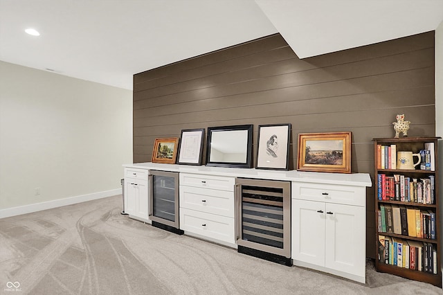 bar featuring light carpet, a bar, and beverage cooler