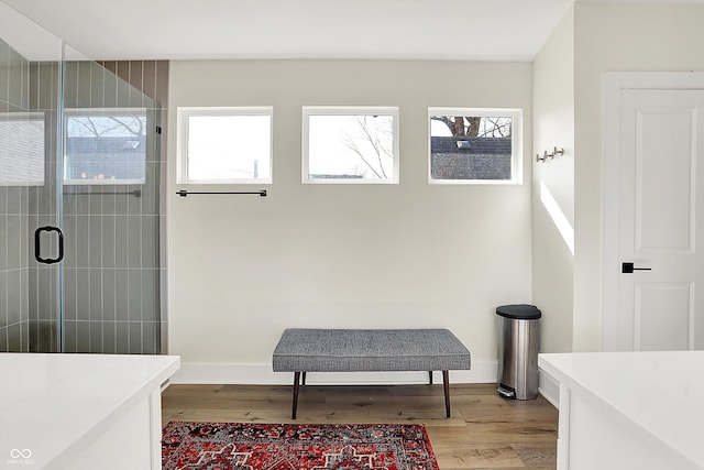 bathroom featuring baseboards, tiled shower, and wood finished floors