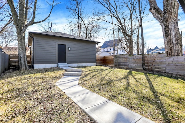 view of outdoor structure featuring entry steps, an outdoor structure, and a fenced backyard