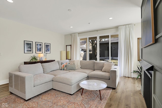 living room with recessed lighting, light wood-type flooring, and baseboards