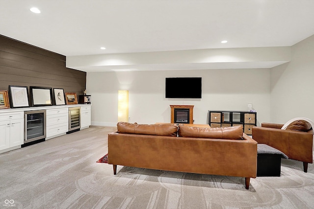 living area with light carpet, recessed lighting, wine cooler, wood walls, and a dry bar