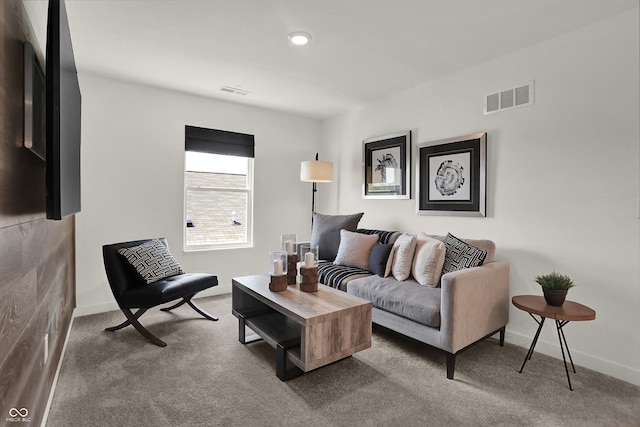 living area with visible vents, baseboards, and carpet floors