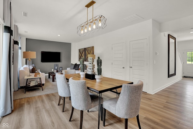 dining space featuring visible vents, light wood-type flooring, and baseboards