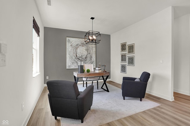 home office featuring baseboards, a chandelier, and light wood finished floors