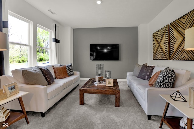 carpeted living room with visible vents and baseboards