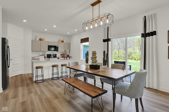 dining room with light wood-style flooring, recessed lighting, and baseboards