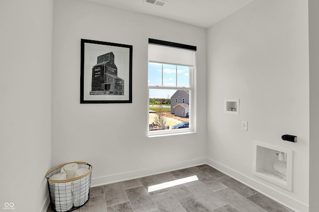 washroom with visible vents, stone finish flooring, baseboards, washer hookup, and laundry area