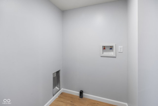 clothes washing area featuring hookup for a washing machine, baseboards, light wood-style flooring, and laundry area