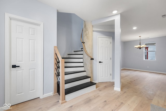 stairway featuring wood finished floors, visible vents, baseboards, an inviting chandelier, and recessed lighting