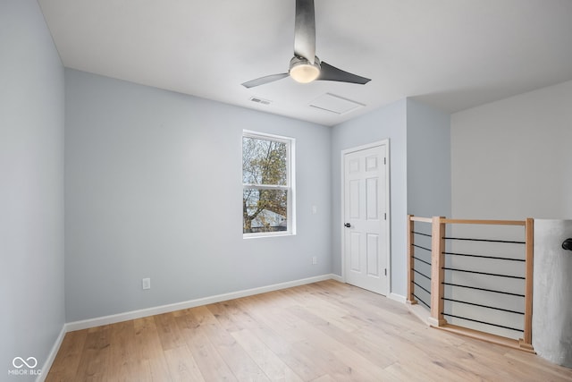 unfurnished room featuring visible vents, wood finished floors, baseboards, attic access, and ceiling fan