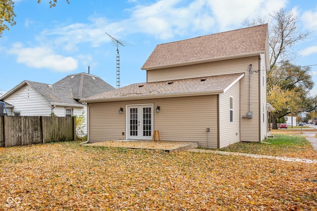 back of property featuring french doors, fence, and roof with shingles