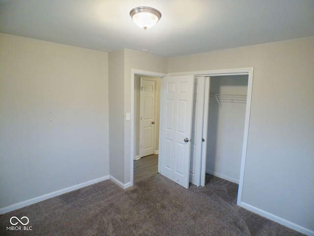 unfurnished bedroom featuring a closet, baseboards, and carpet floors