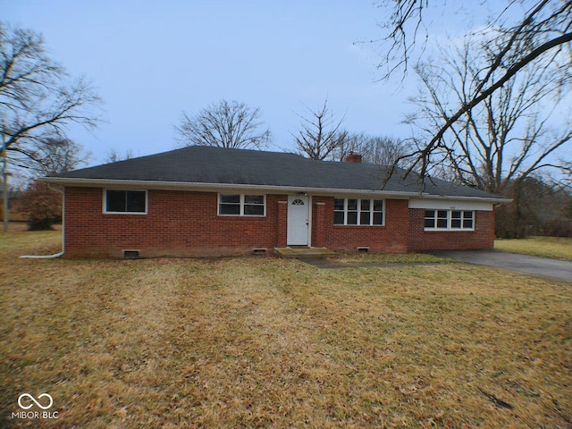 ranch-style house featuring a front yard, a chimney, brick siding, and crawl space