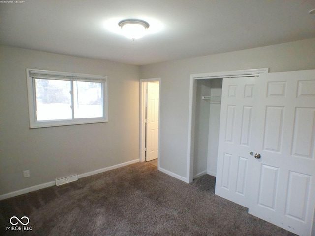 unfurnished bedroom featuring baseboards, carpet floors, a closet, and visible vents