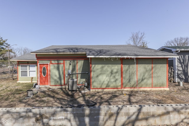 view of front facade with cooling unit and roof with shingles