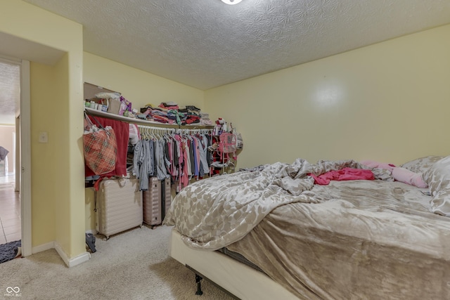 bedroom featuring carpet flooring, baseboards, a closet, and a textured ceiling