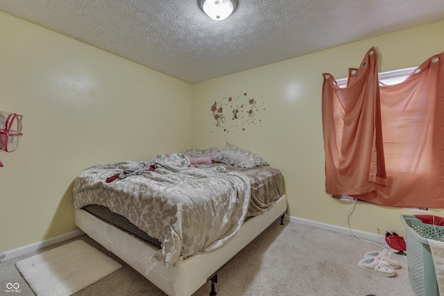 carpeted bedroom with baseboards and a textured ceiling