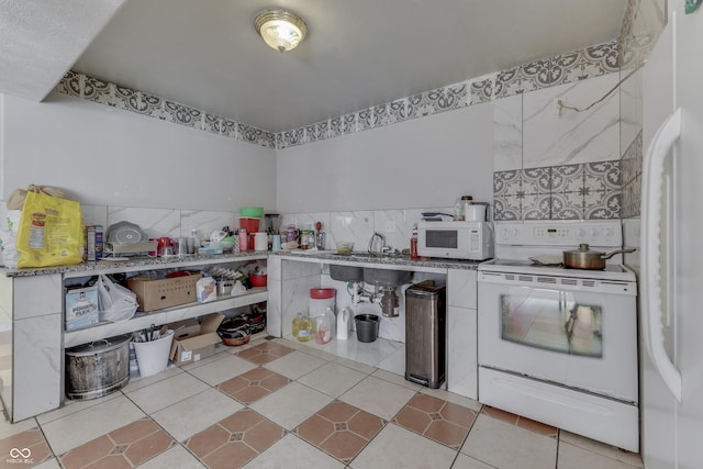 kitchen with light tile patterned floors and white appliances