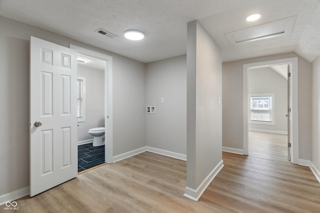 bathroom featuring toilet, wood finished floors, visible vents, and a textured ceiling