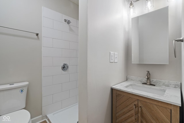 full bath with vanity, toilet, and tiled shower