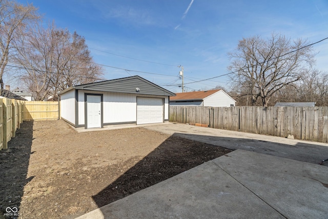 detached garage with concrete driveway and fence