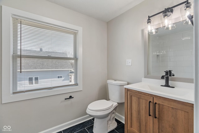 bathroom with tile patterned flooring, toilet, vanity, and baseboards