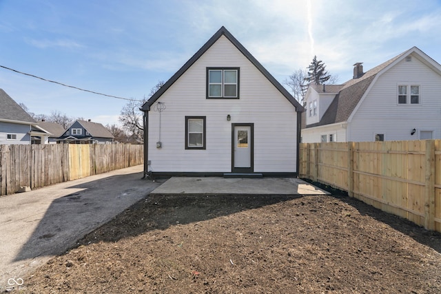 rear view of house with a patio area and a fenced backyard