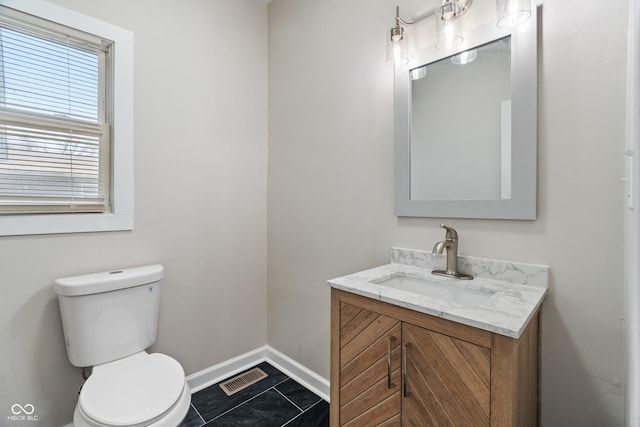 half bathroom with vanity, baseboards, visible vents, tile patterned floors, and toilet