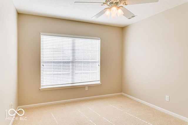 carpeted empty room with a wealth of natural light, visible vents, baseboards, and a ceiling fan