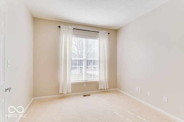 carpeted spare room with baseboards and visible vents