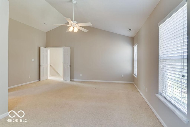 empty room featuring high vaulted ceiling, a ceiling fan, baseboards, and light carpet