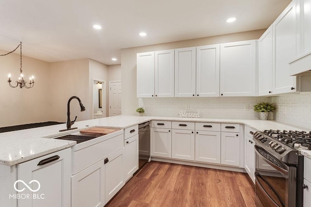 kitchen with white cabinets, gas stove, light wood-type flooring, and a sink