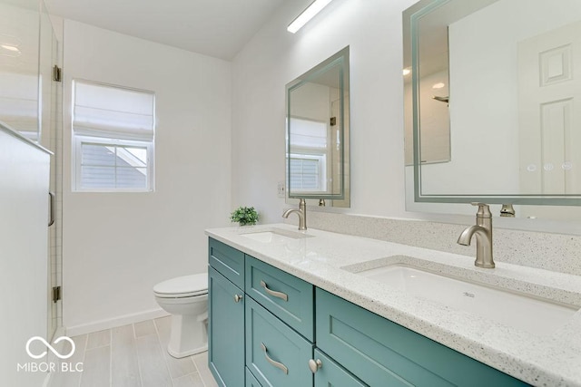 bathroom with double vanity, an enclosed shower, toilet, and a sink