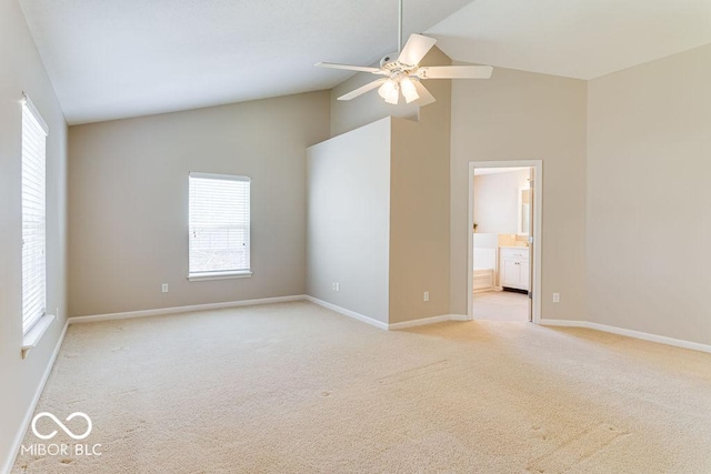 spare room featuring baseboards, light carpet, high vaulted ceiling, and ceiling fan