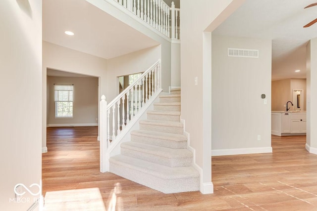 stairs featuring wood finished floors, visible vents, baseboards, recessed lighting, and ceiling fan