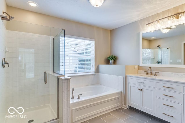 full bath featuring tile patterned floors, a garden tub, vanity, and a shower stall