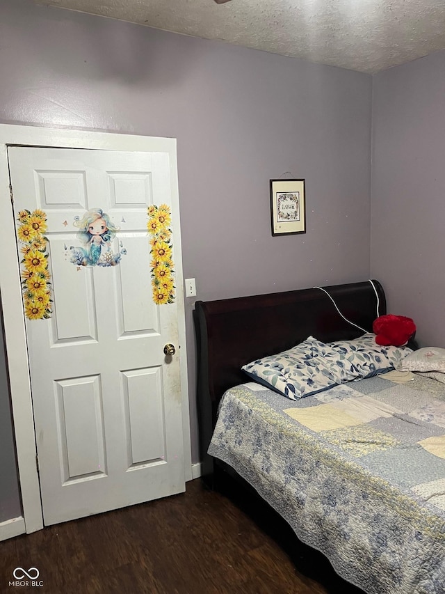 bedroom with dark wood-type flooring and a textured ceiling