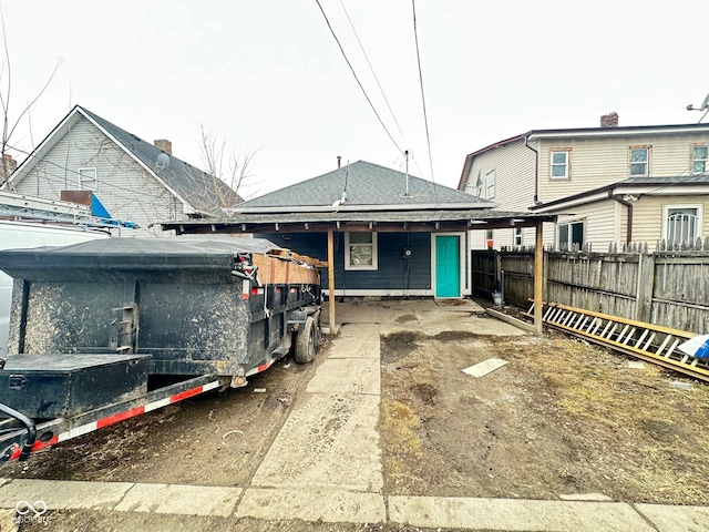 exterior space featuring roof with shingles and fence