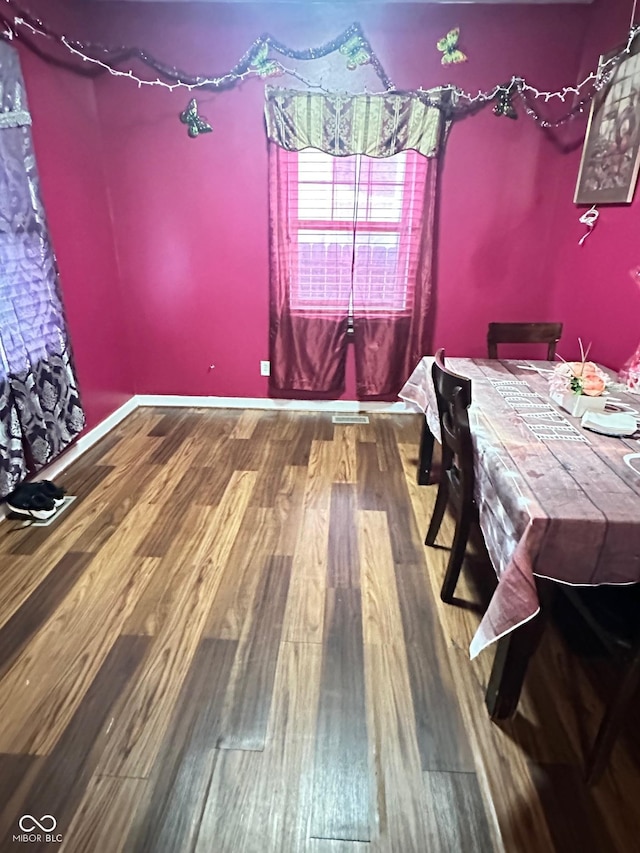 dining area with baseboards and wood finished floors