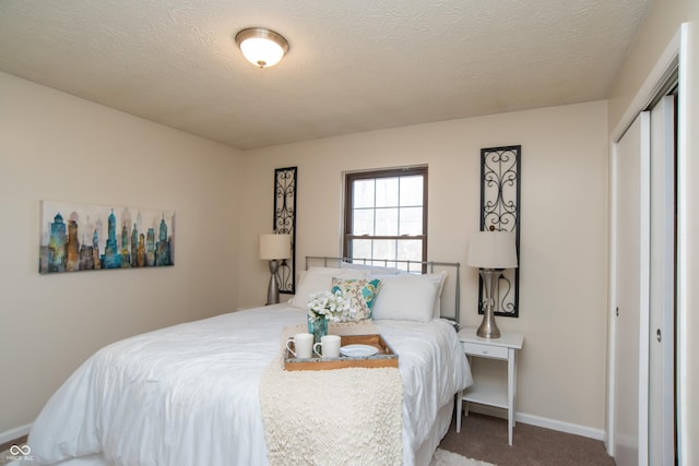 carpeted bedroom featuring a closet, baseboards, and a textured ceiling