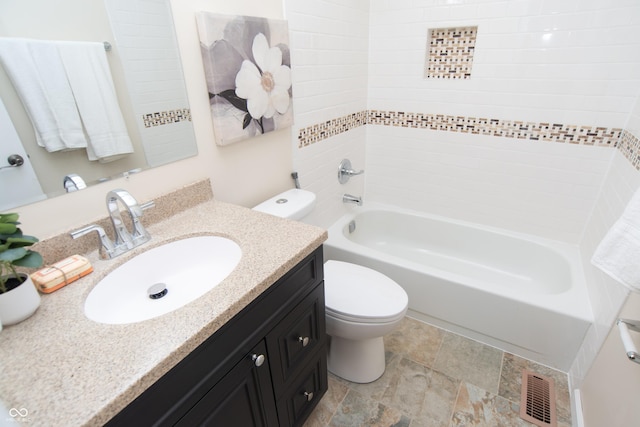 bathroom featuring visible vents, stone finish flooring, toilet, bathing tub / shower combination, and vanity