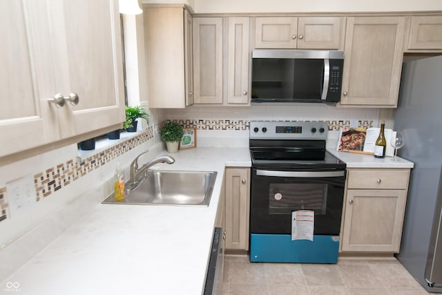 kitchen featuring a sink, decorative backsplash, appliances with stainless steel finishes, and light countertops