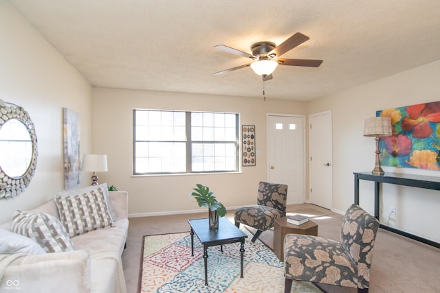 carpeted living area featuring baseboards, a textured ceiling, and ceiling fan