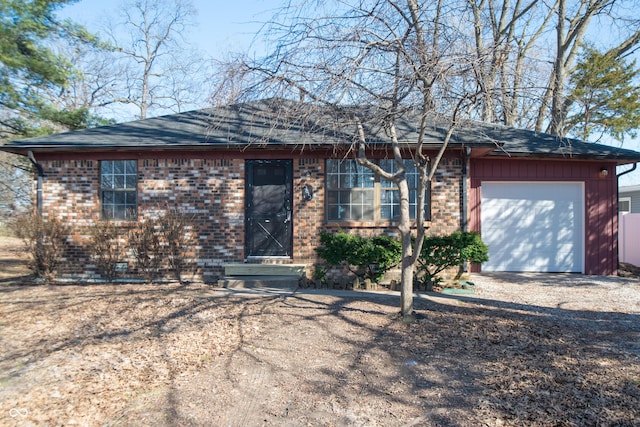 ranch-style home featuring a garage, brick siding, and roof with shingles